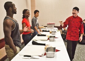 Students Vernon Jeffries, Victoria Kinabo and Cesar Merino prepare for the competi- tion as Chef Brent Gorman explains the rules. | Johnny Peña/The Daily Cougar
