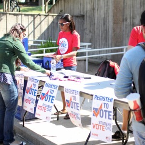Taylor Tompson (center) helps a student register to vote. Students can stop by any booth today to register to vote for the November 2012 presidential and congressional elections. | Rebekah Stearns/The Daily Cougar