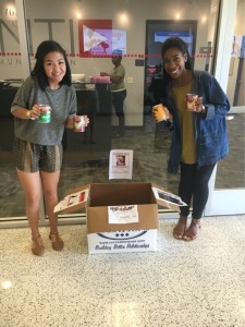 Avery Pham, and Charnee Collier, students in Emery's public relations class, pose in front of the donation box outside the Valenti office,