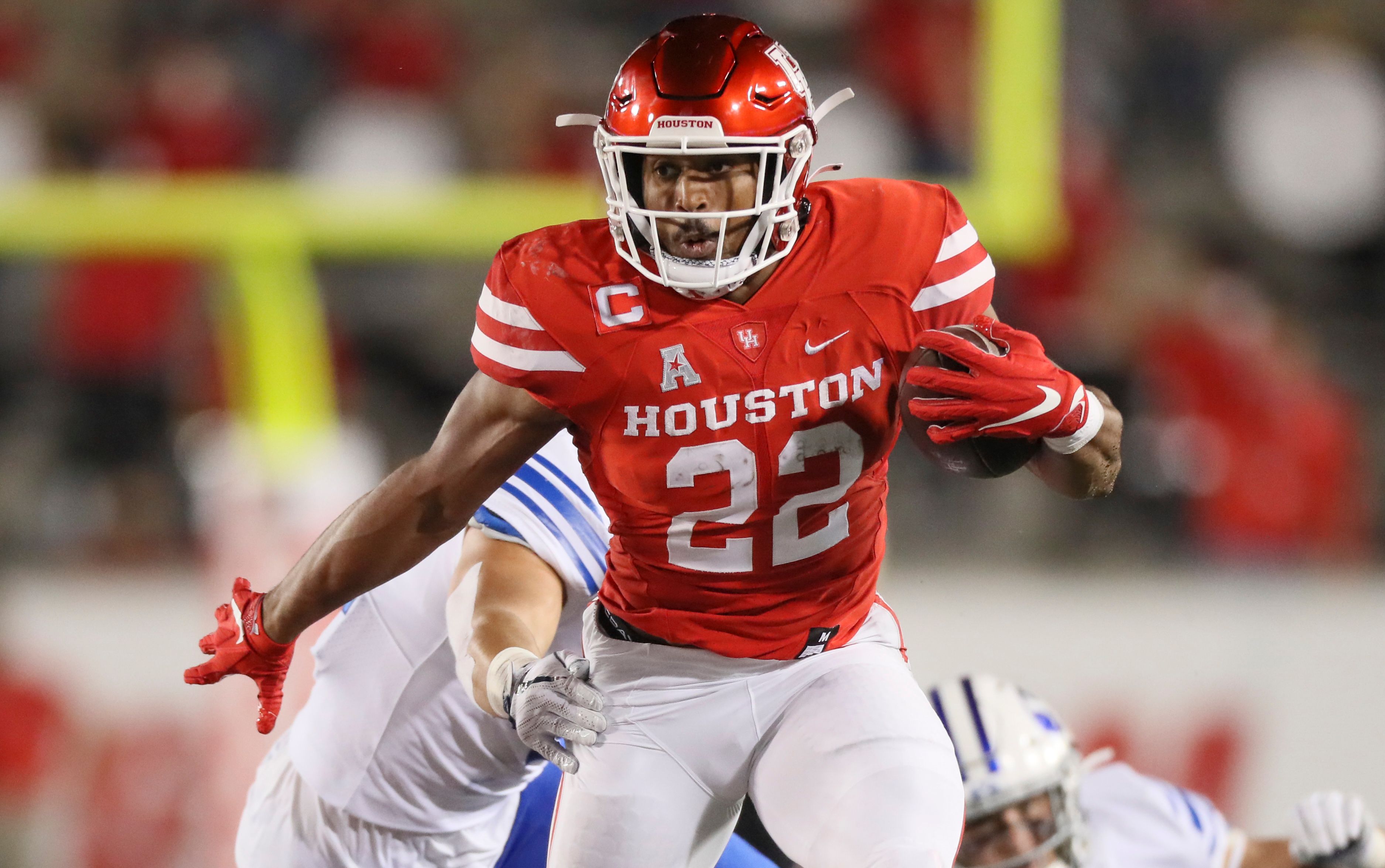 Senior running back Kyle Porter carries the football and tries to power through the grip of a BYU defender during a game at TDECU Stadium in the 2020 season. | Courtesy of UH athletics