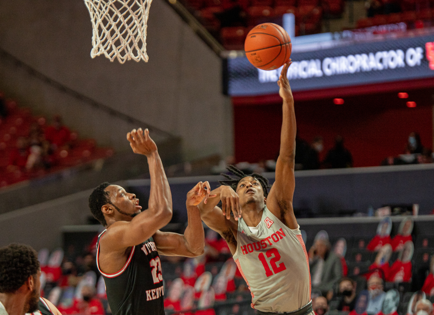 UH men's basketball guard Tramon Mark (12) eases his way around Western Kentucky center Charles Bassey for the layup on Feb. 25 at Fertitta Center. UH will host USF on Sunday. | Andy Yanez/The Cougar
