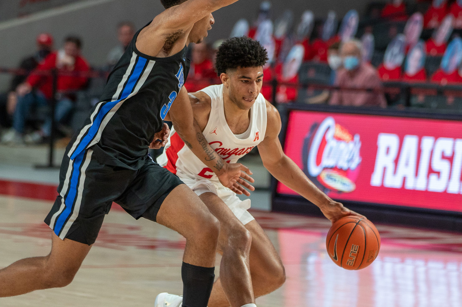 UH junior guard Quentin Grimes dribbles with his left hand as he is draped by a Memphis defender during a game on March 7 at Fertitta Center. | Andy Yanez/The Cougar