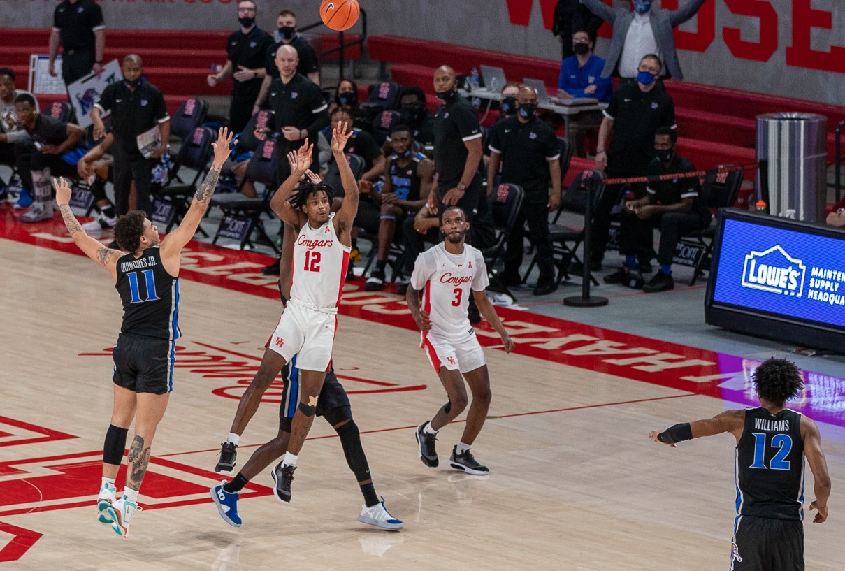 UH men's basketball guard Tramon Mark releases a shot from near half-court as time expires against Memphis. After Mark's shot went in, all of his teammates erupted with excitement as they swarmed the freshman guard on the opposite end of the court. | Andy Yanez/The Cougar 