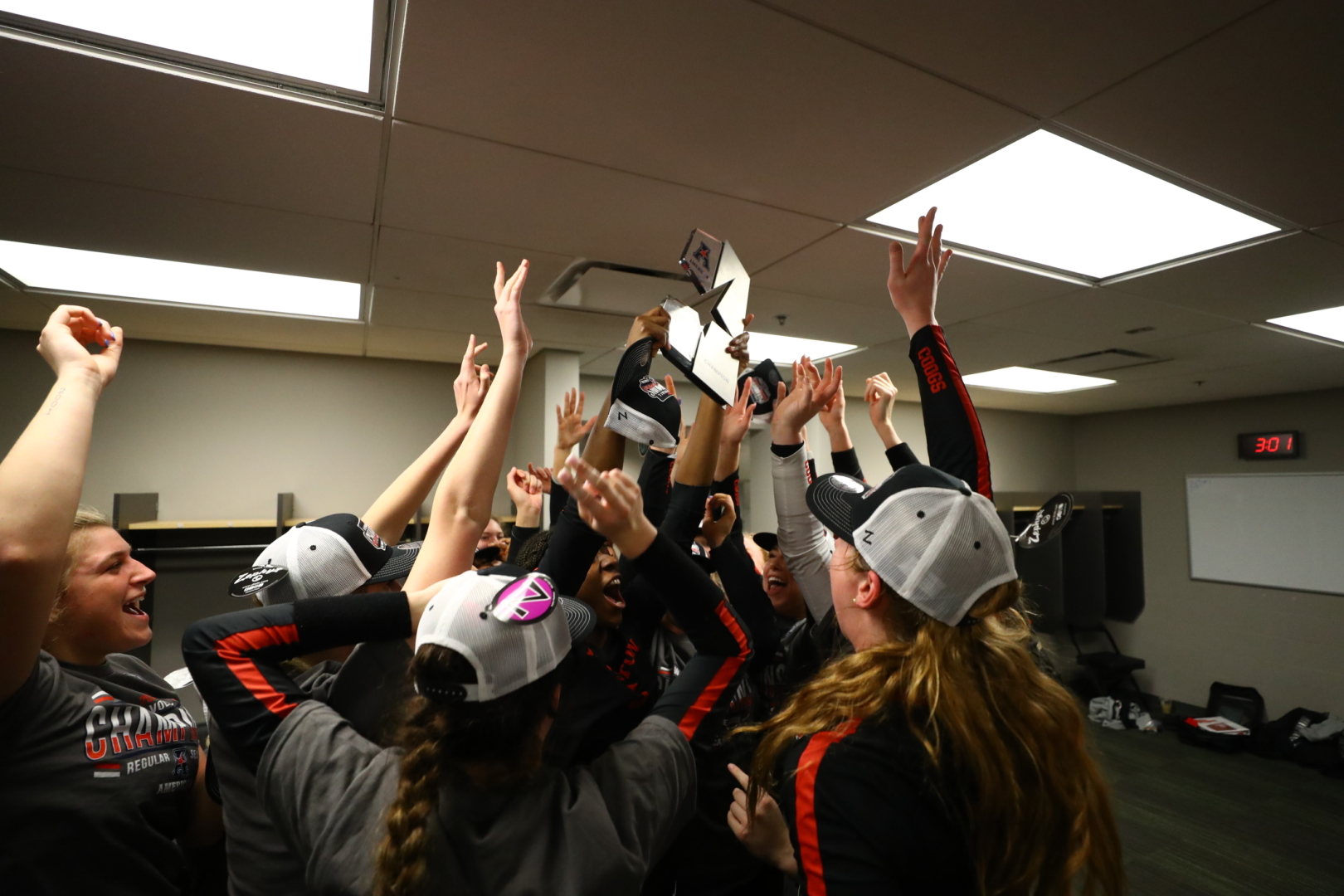 The UH volleyball team hoists their conference title trophy in their locker room. | Courtesy of UH athletics