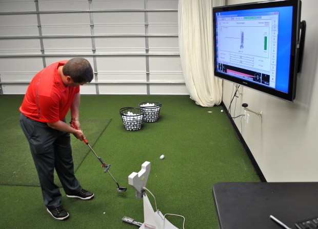 Third year head coach Jonathan Dismuke utilizes the SAM PuttLab of the facility’s many technological advancements which allows players to analyze their stroke.   |  Photo courtesy of UH Athletics