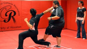 Mechanical engineering and mathemetics junior Bryan Lopez, left, spars with self-defense instructor Threz Gonzalez, center, while chemistry graduate Bicole Flores, right, looks on. Classes like this and the Cougar Aikido Club teach students defense and awareness | Aisha Bouderdaben/The Daily Cougar
