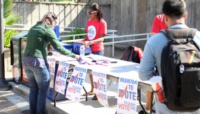 Taylor Tompson (center) helps a student register to vote. Students can stop by any booth today to register to vote for the November 2012 presidential and congressional elections. | Rebekah Stearns/The Daily Cougar