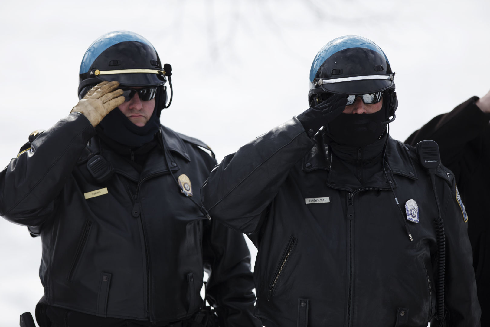 Two police officers salute the American flag during a remembrance ceremony at the Marine Corps War Memorial in Washington. The ceremony commemorated the 70th anniversary of the battle for Iwo Jima. With most of the surviving veterans in their 80s and 90s, surviving Marines visited the memorial in remembrance of their brothers in arms. (U.S. Marine Corps photo by Cpl. Clayton Filiopwicz/Released)