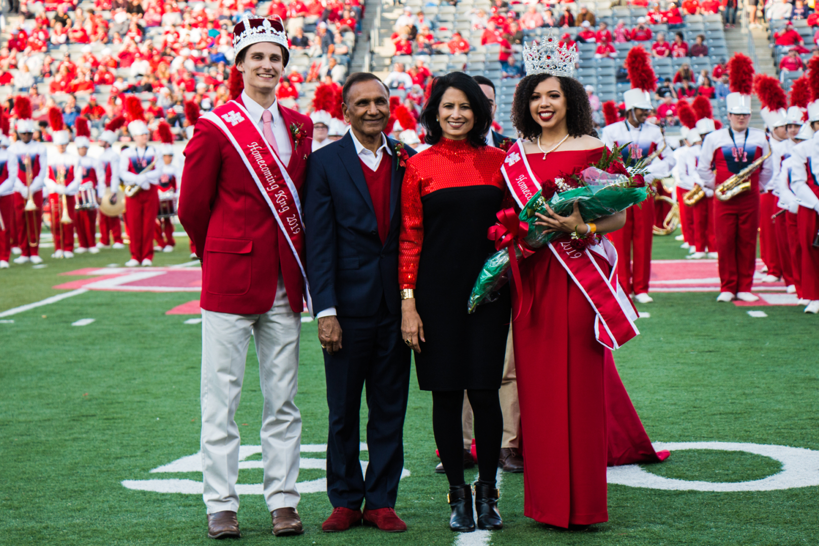 Business management senior John Austin Schaudel and hotel and restaurant management senior Chelsea Lawson pictured with President Renu Khator and her husband Suresh Khator. Lawson and Schaudel were crowned homecoming king and queen during halftime of the Memphis versus Houston game. | Jiselle Santos/The Cougar