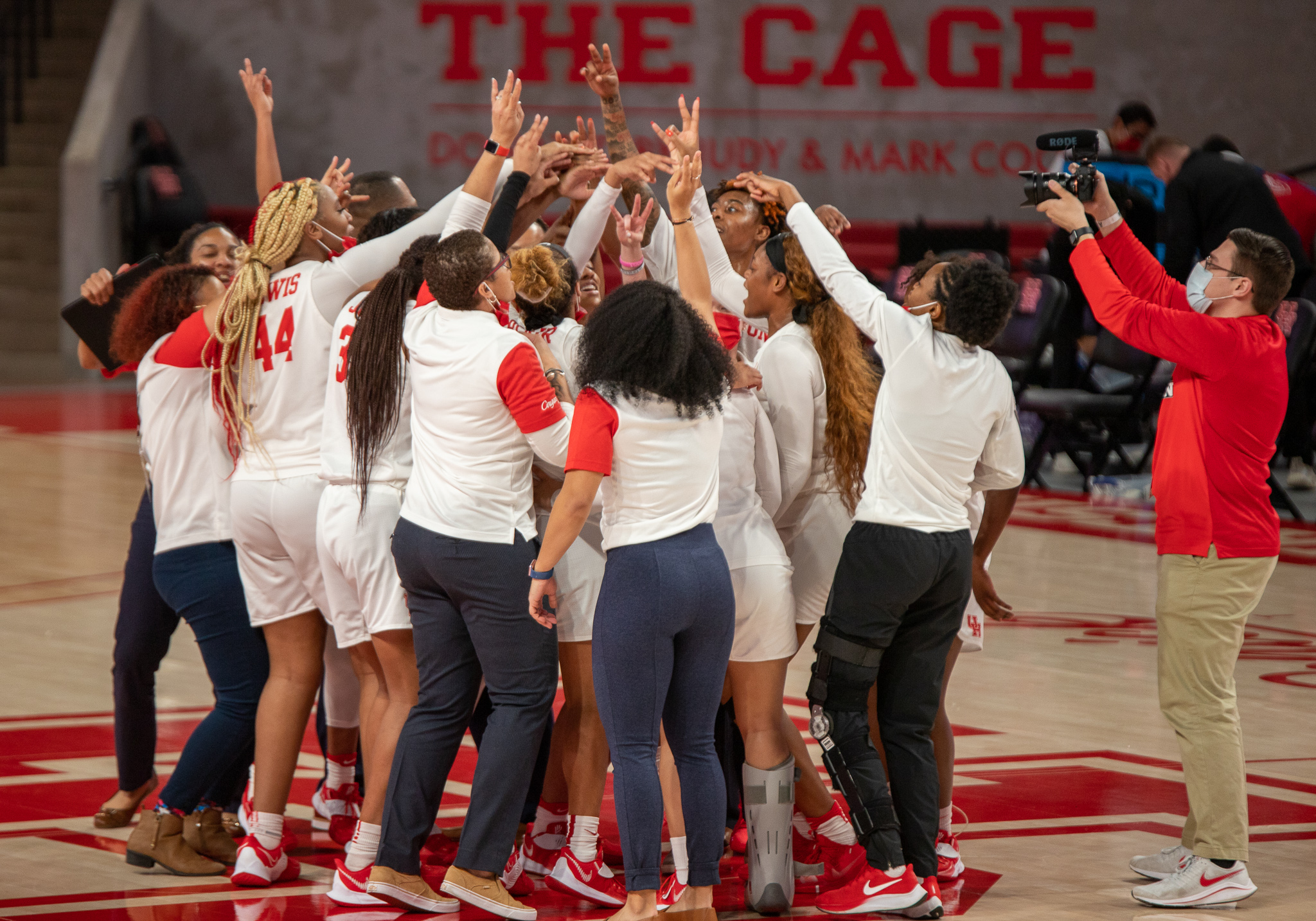 The UH women's basketball team coaches and players come together at the half-court line and celebrate their win over No. 13 USF. | Andy Yanez/The Cougar