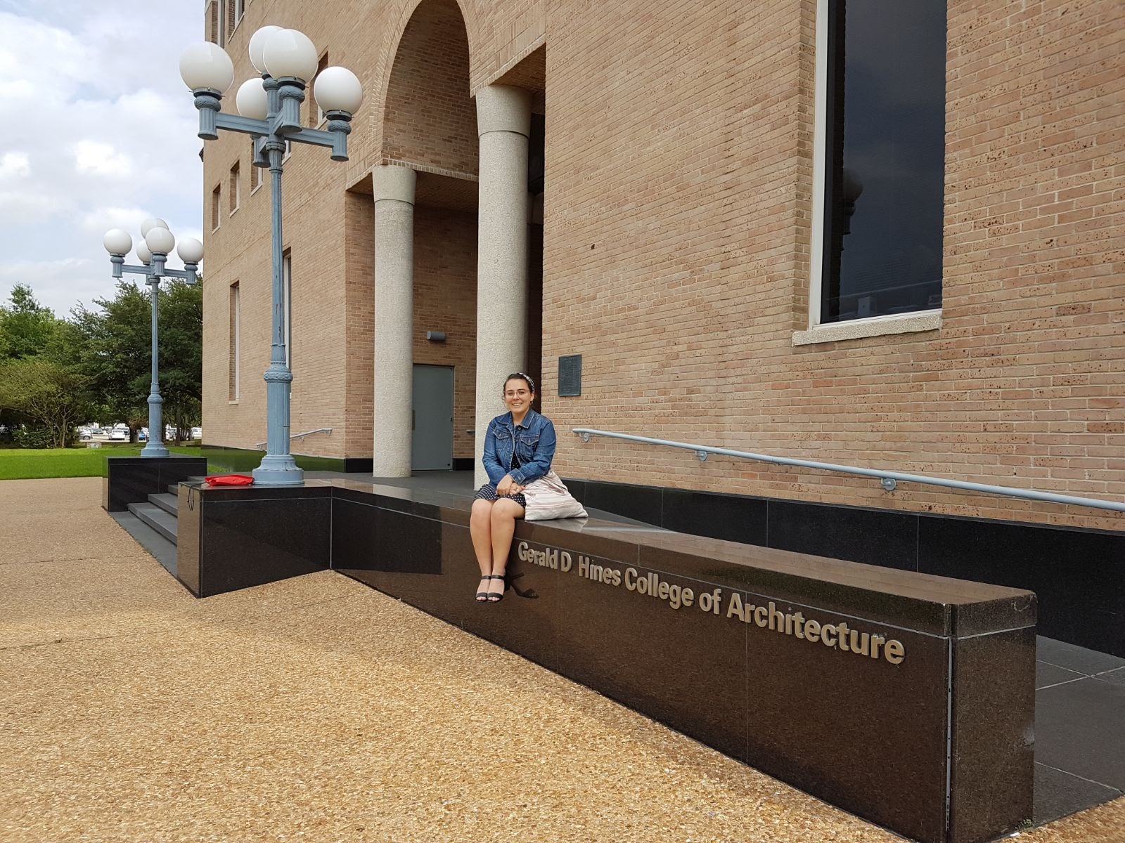 Maria, the primary focus of the story, sits atop a ledge in front of the entrance to the College of Architecture and Design