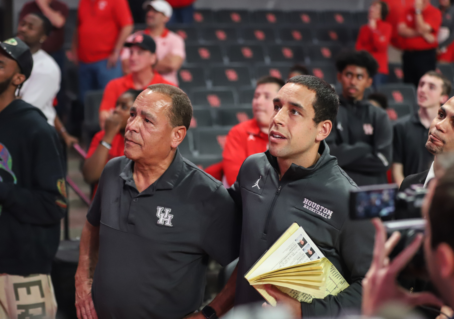 Kelvin Sampson watches the tribute video alongside his son and UH assistant coach Kellen. | Sean Thomas/The Cougar